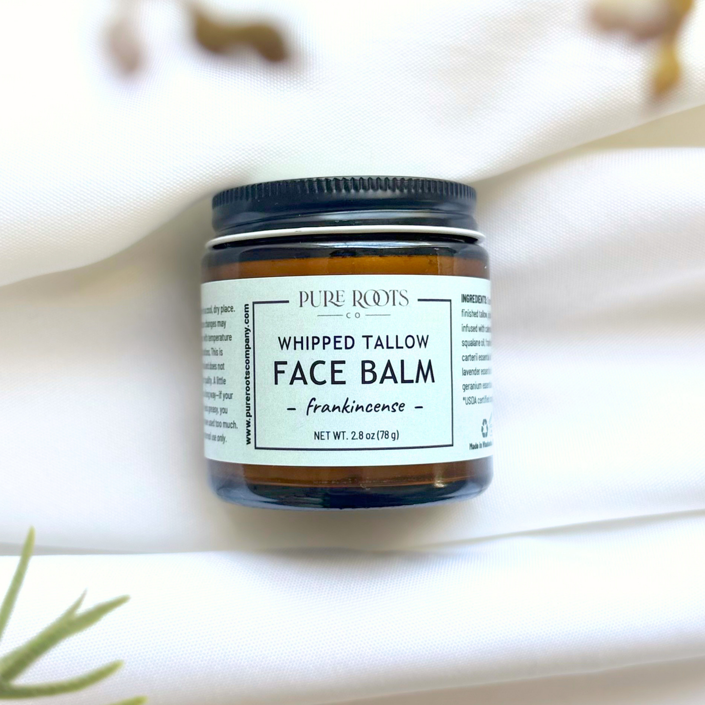 Jar of whipped tallow balm with a label on a light background