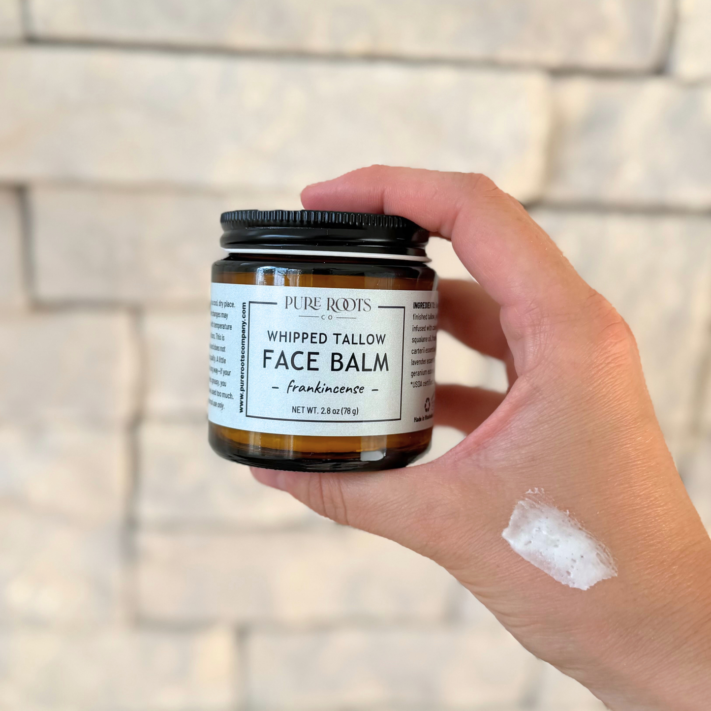 Jar of whipped tallow balm with a label on a light background